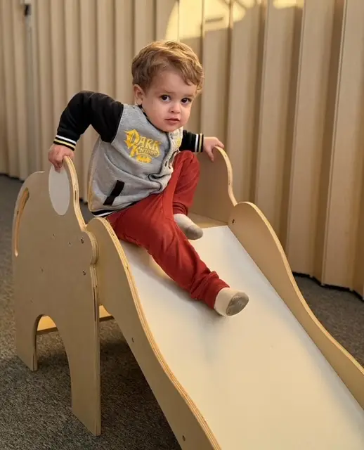 Preschool child having fun sliding down