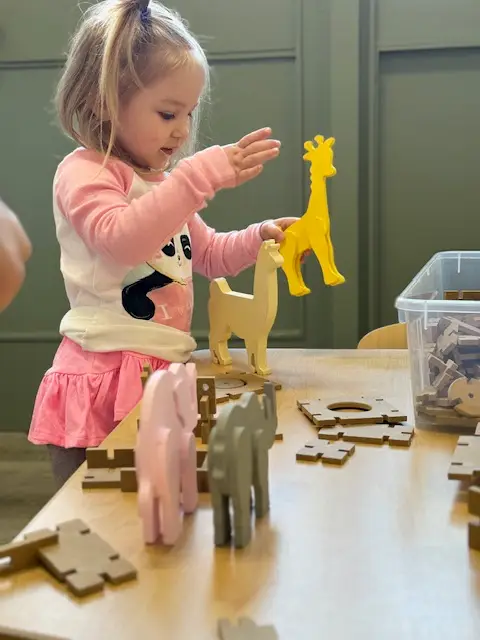 Preschool girl playing with a yellow giraffe toy